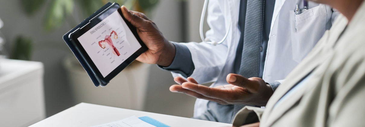 Close up doctor holding tablet with female reproductive health charts
