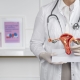 Front view doctor holding anatomic model showing how uterine fibroid embolisation works