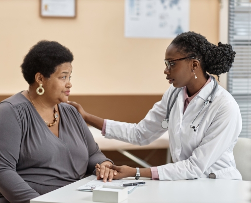 A young doctor tackling uterine fibroid embolisation myths in a consultation with a patient