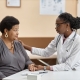 A young doctor tackling uterine fibroid embolisation myths in a consultation with a patient