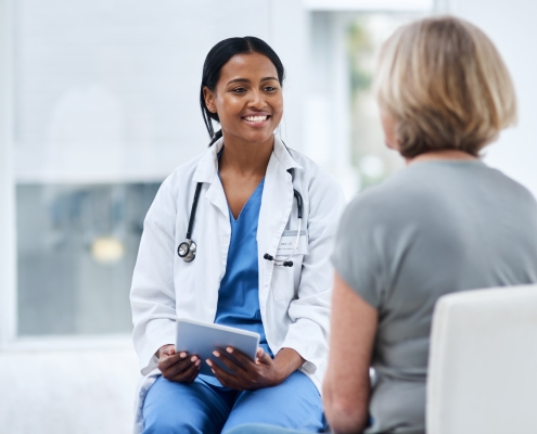 A female doctor discussing UFE and menopause with a mature patient