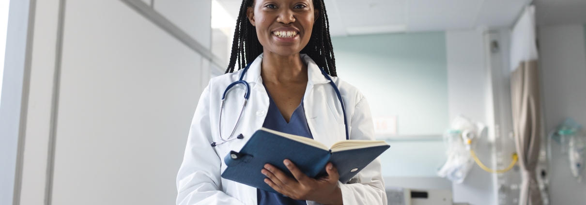 Happy female fibroid embolisation specialist in Johannesburg, standing in a clinic