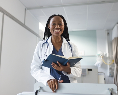 Happy female fibroid embolisation specialist in Johannesburg, standing in a clinic