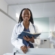 Happy female fibroid embolisation specialist in Johannesburg, standing in a clinic