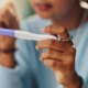 A close-up of a young woman looking at a pregnancy test to show the impact of UFE and future pregnancies.
