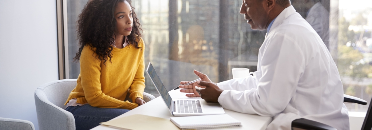 A woman having a consultation with her doctor about UFE vs. myomectomy vs. hysterectomy options.