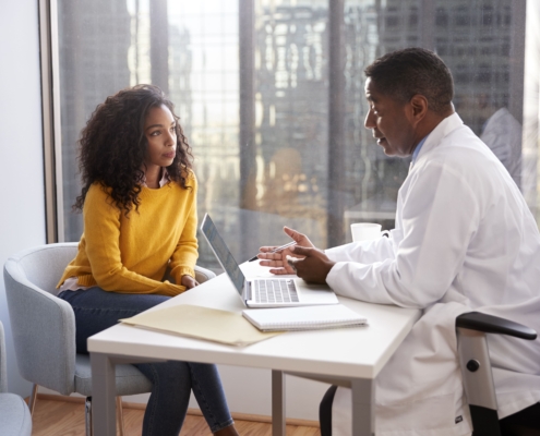 A woman having a consultation with her doctor about UFE vs. myomectomy vs. hysterectomy options.