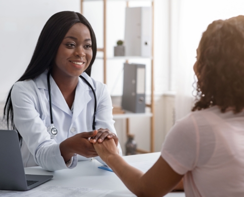 A doctor holding a patient’s hand and addressing questions about UFE