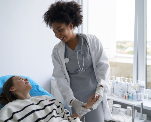 A doctor attending to a patient lying in a hospital bed while applying UFE procedure steps.