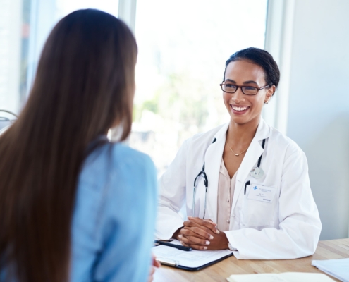 A doctor having a consultation with a patient, answering the question “can adenomyosis be treated with UFE?”