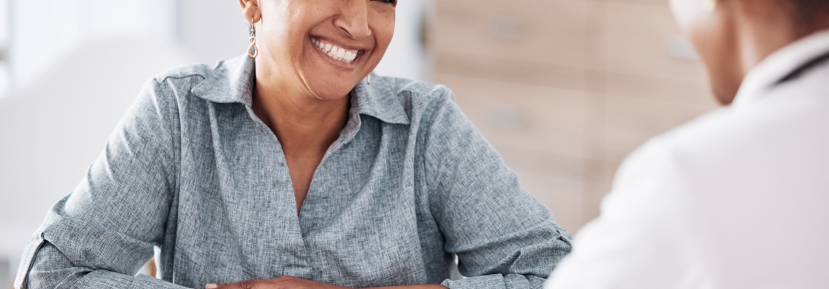 An older woman smiling during a doctor’s consultation for UFE over 45