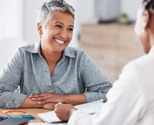 An older woman smiling during a doctor’s consultation for UFE over 45