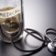 Coins in a medical savings jar next to a stethoscope for UFE fibroids cost.