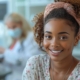 A young woman smiling in a clinic, learning about the minimum age for UFE